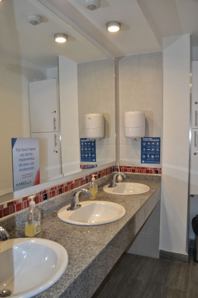 Lavamanos limpios y modernos en los baños de Coworking Marbella, con dispensadores de jabón y papel, reflejando el compromiso con la higiene y el bienestar.