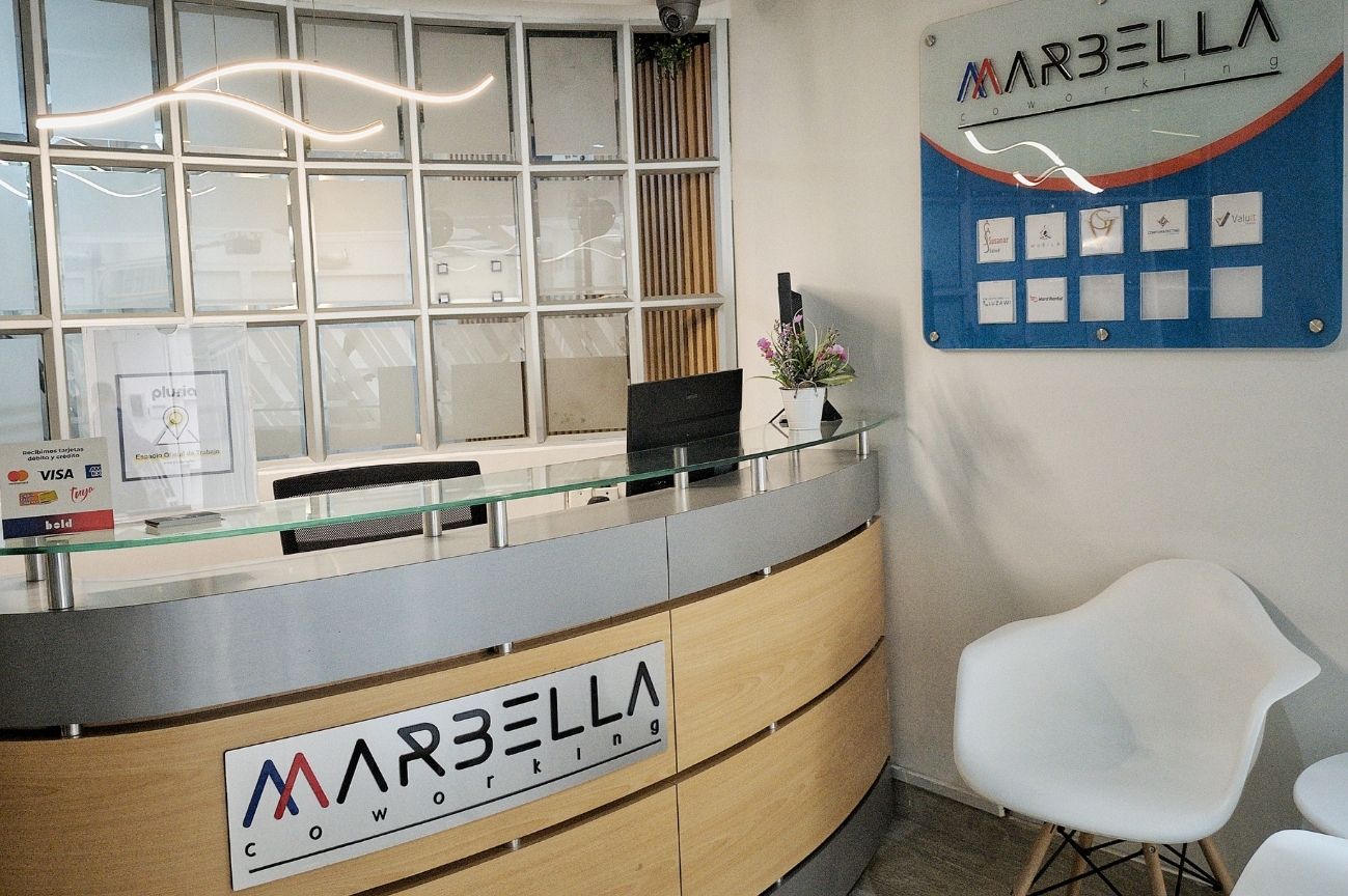 Recepción principal de Coworking Marbella, punto de atención para servicios de oficina virtual y visitantes, con logo visible y ambiente profesional en Bogotá.